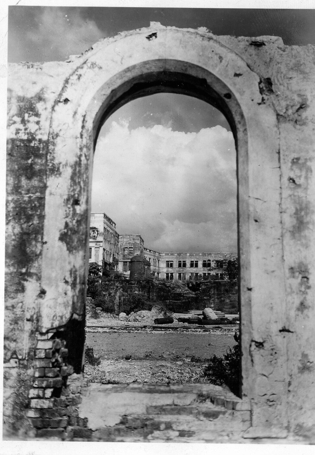 War-Damaged European Building Viewed Through a Ruined Archway