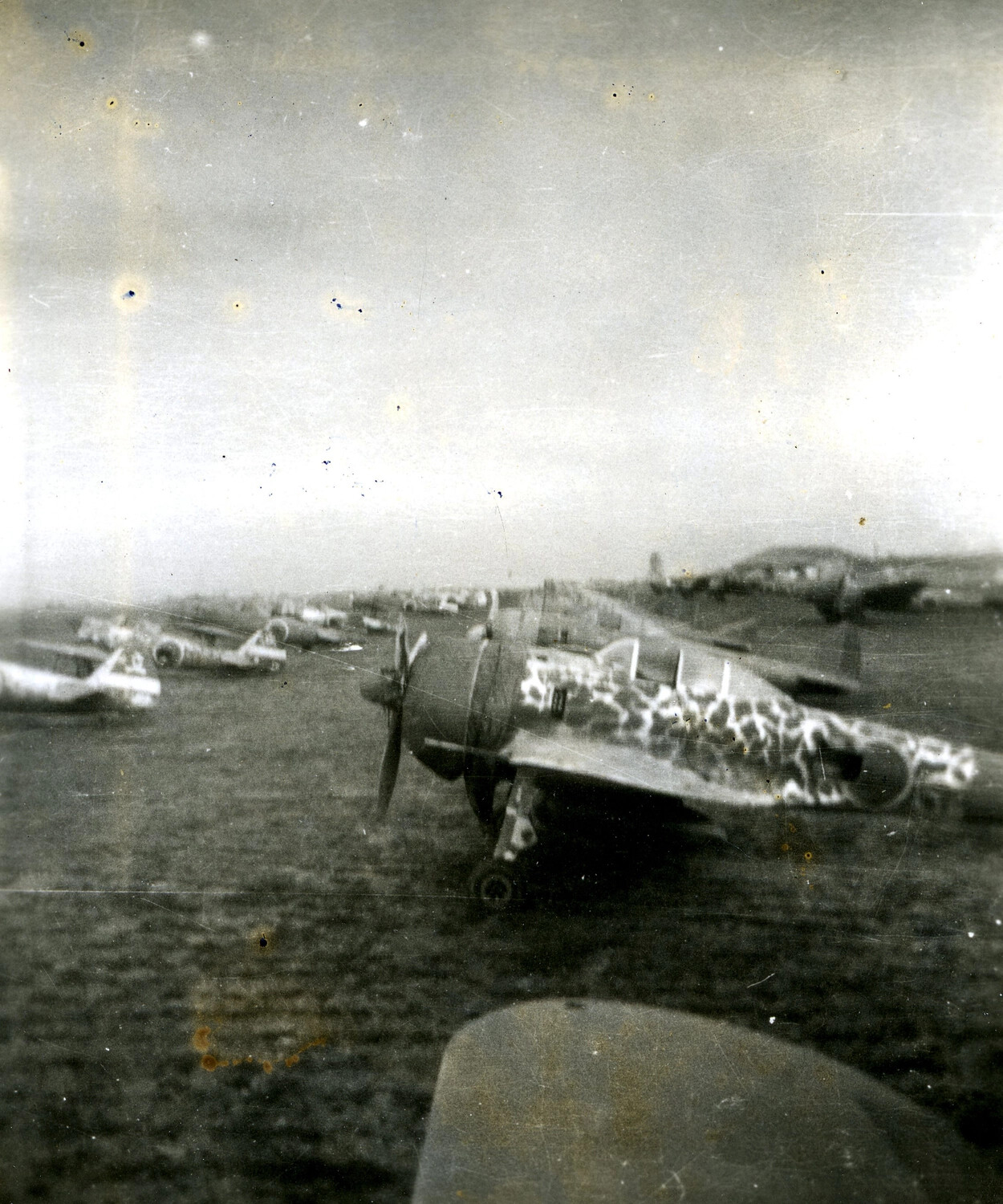 Row of Camouflaged Japanese Fighter Aircraft on Captured Airfield