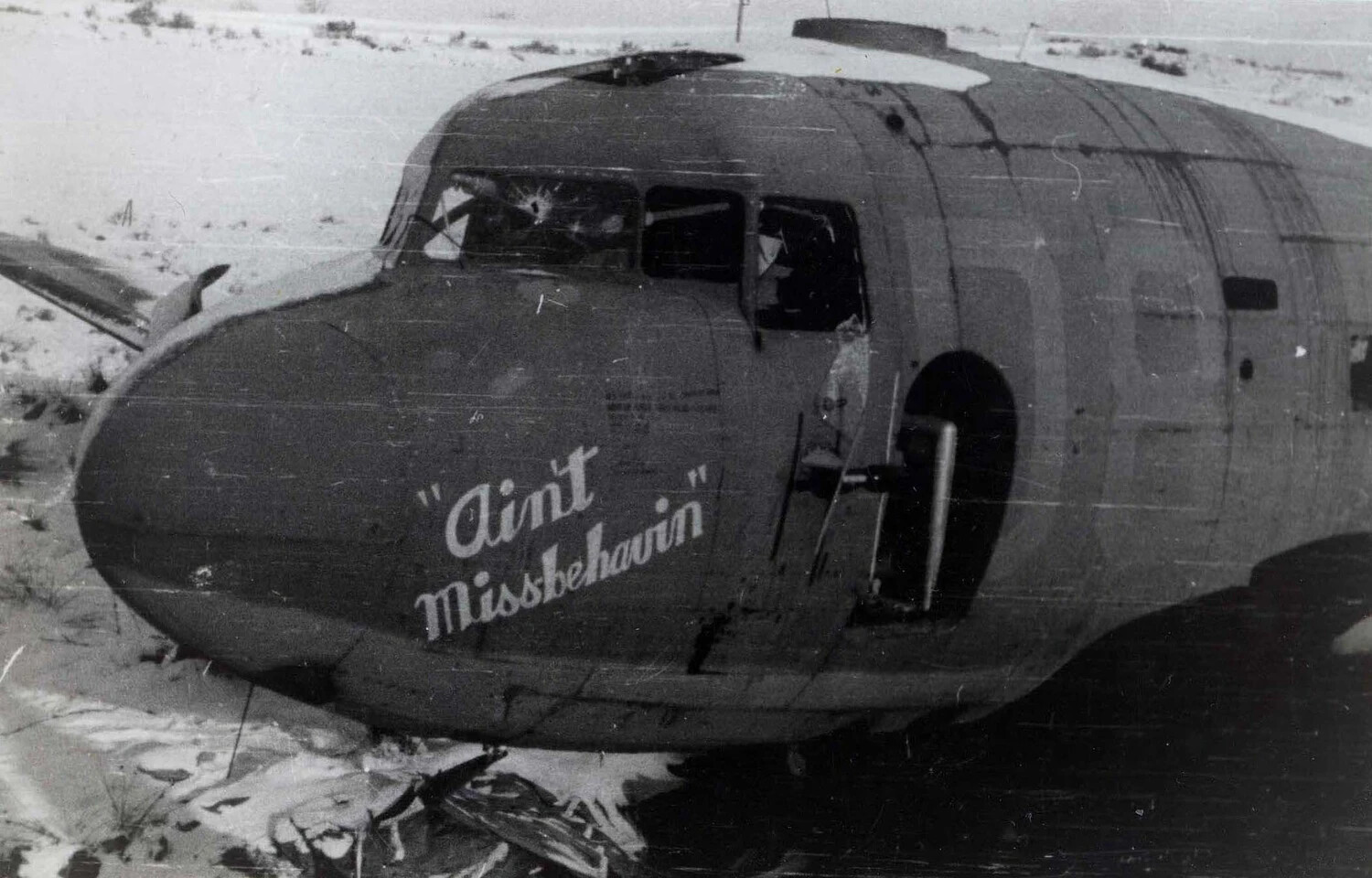Crash-Landed Aircraft Nose with 'Ain't Missbehavin'' Nose Art, Snow-Covered Field, WWII