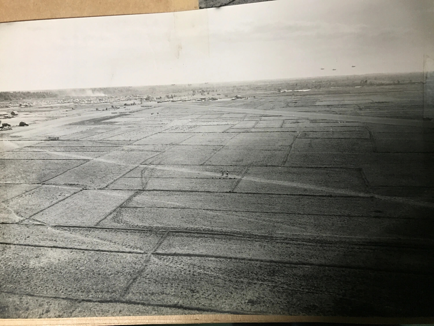 Low-Altitude Aerial View of Cultivated Fields with Aircraft Formation and Distant Encampment, Southwest Pacific Theater