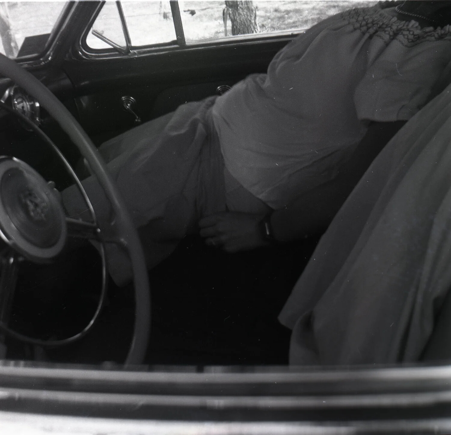 Candid Interior View of Vintage Automobile with Passenger's Skirt and Hand, Driver's Seat Perspective