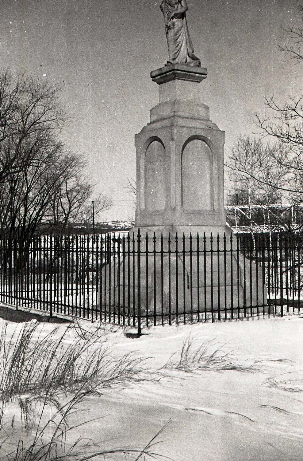 Winter View of a Stone Commemorative Monument Behind Wrought-Iron Fence, New England, WWII Era