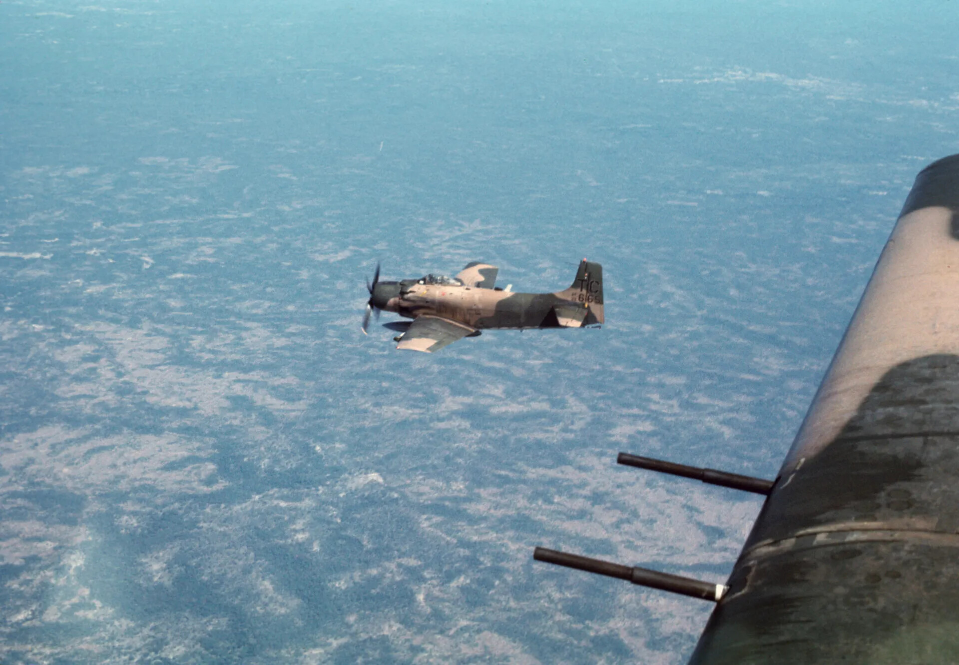 A-1 Skyraider in Flight Over Southeast Asia, Viewed from Escort Aircraft Gun Turret