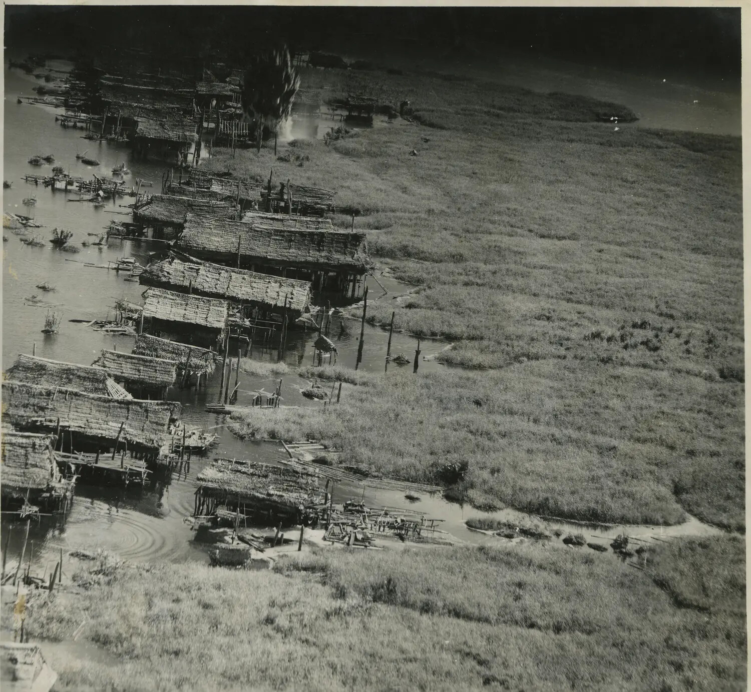 Aerial View of Flooded Riverside Stilt Village, Southwest Pacific Area, World War II Era