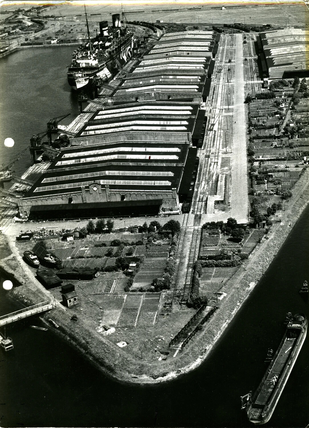 Aerial View of Riverside Dock and Warehouse Complex with Ocean Liner, WWII-Era European Theater