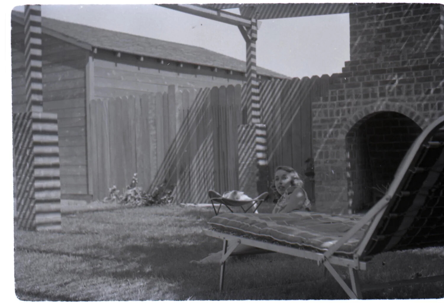 Backyard Scene with Woman Seated on Lawn, Dixon, California, 1950s
