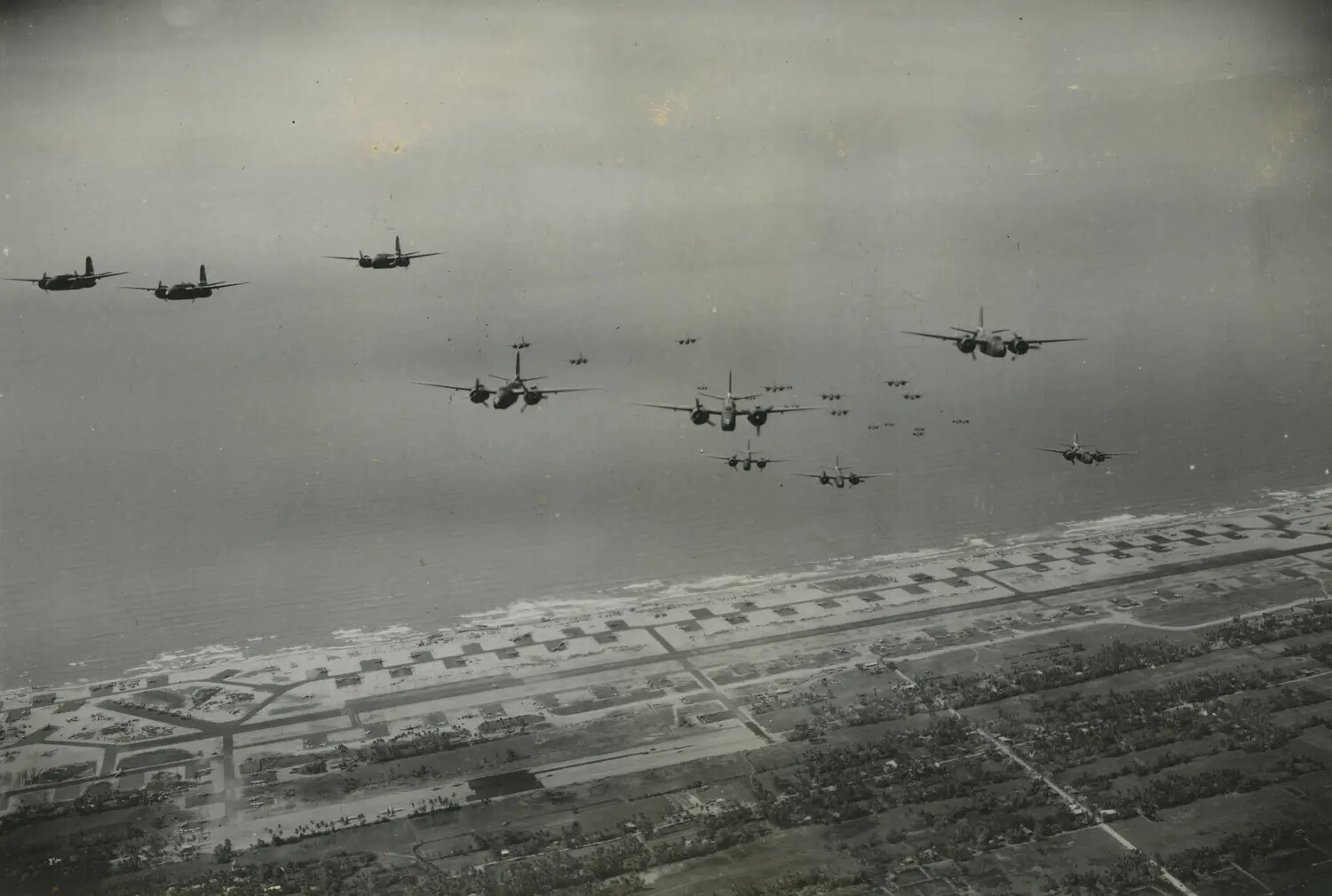 Formation of 312th Bomb Group Attack Aircraft over Coastal Airbase, Southwest Pacific