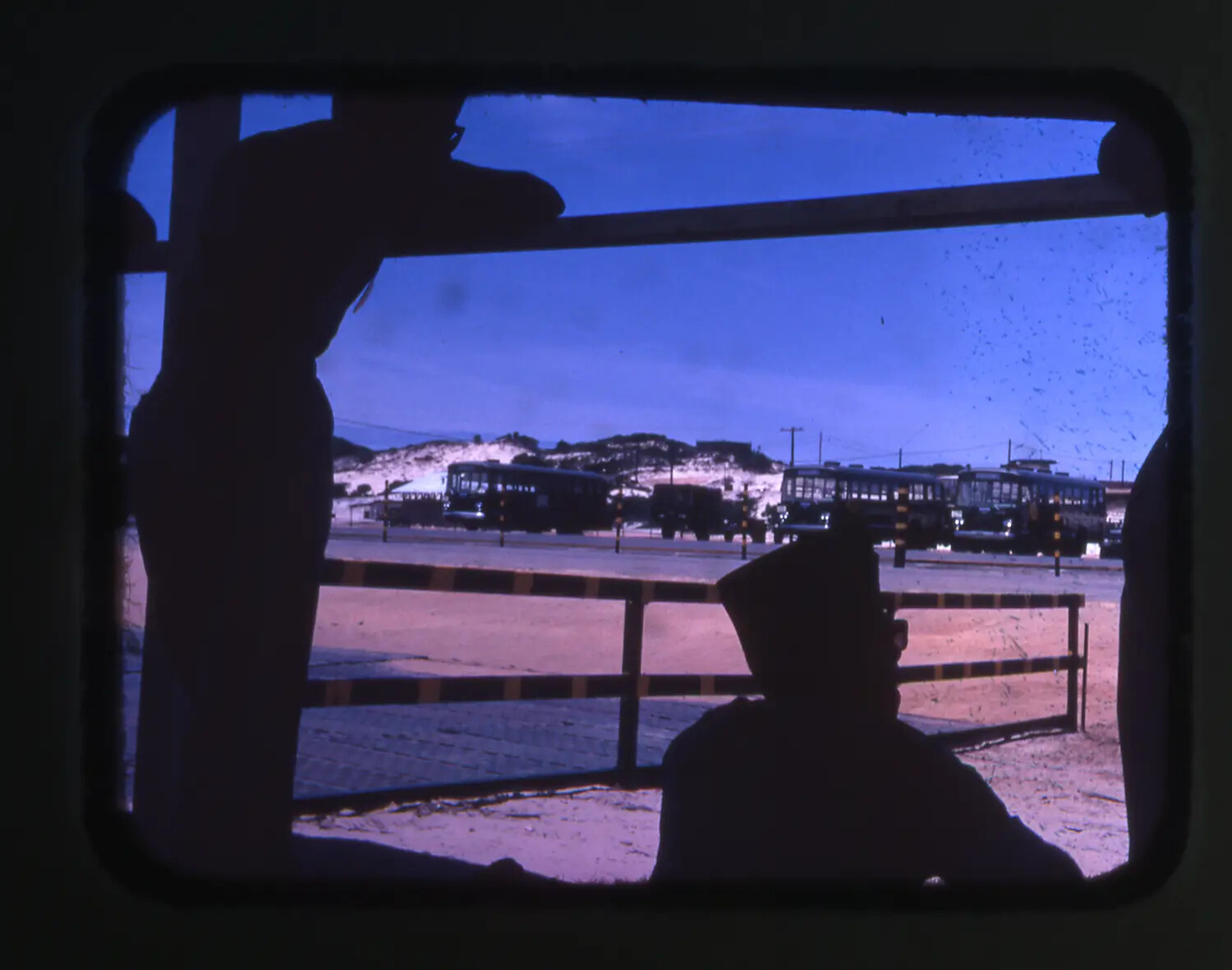 Vietnam War Era Color Slide: Silhouetted Servicemen at Dusk with Parked Buses and Sand Dunes, Cam Ranh Bay, Vietnam