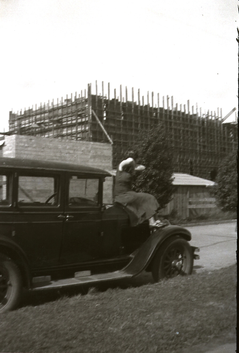 Woman Beside a Vintage Automobile with Bamboo Scaffolding Construction in the Background, China