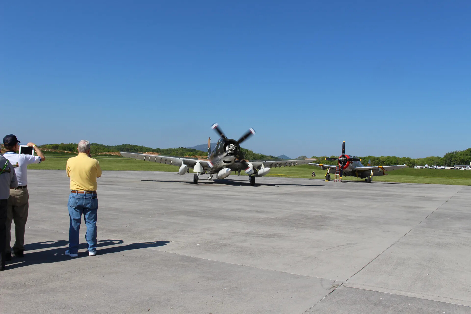 Spectators Photographing an A-1 Skyraider Taxiing at a Warbird Reunion Event