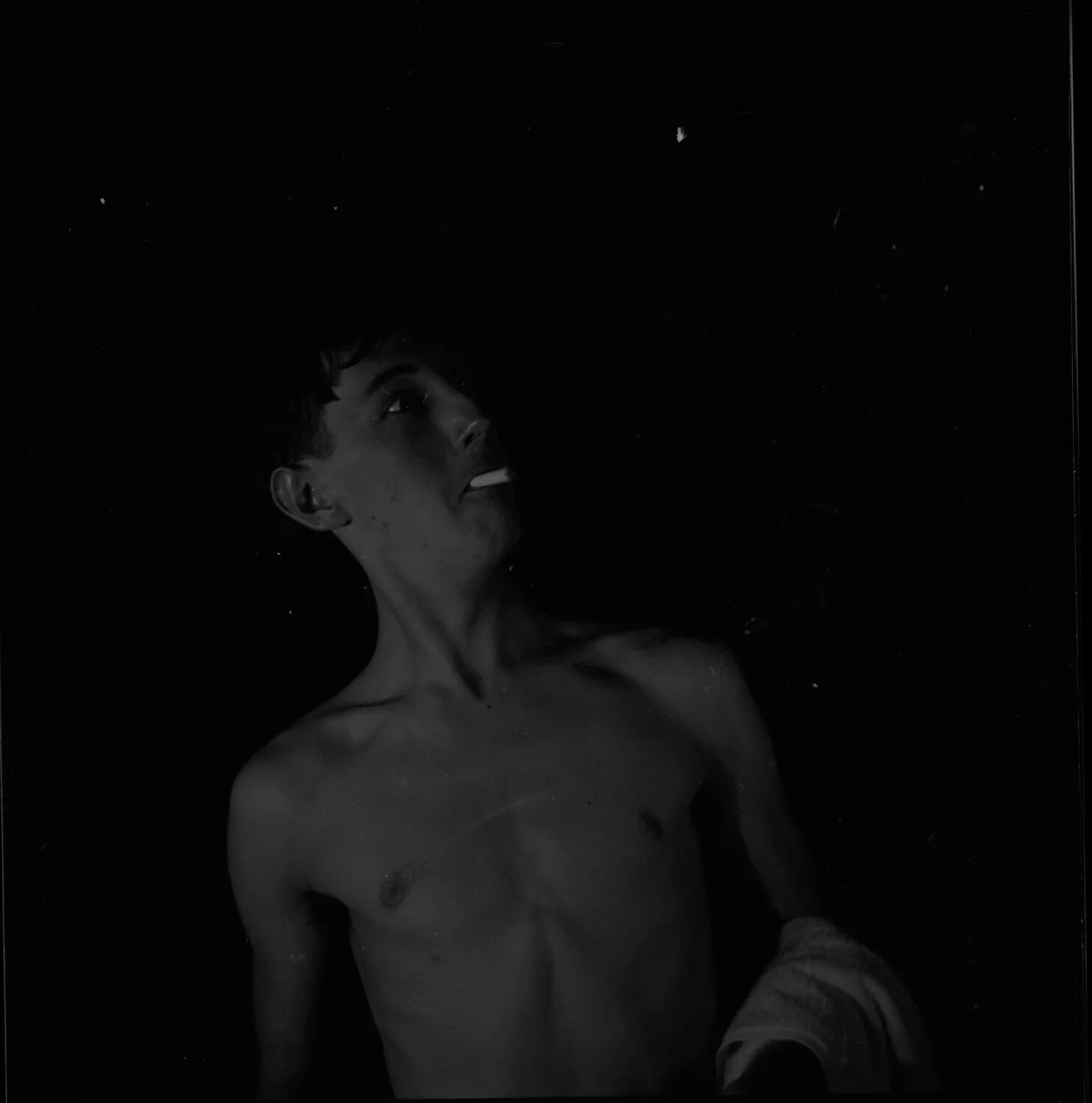 Shirtless Young Man with Cigarette and Towel, Candid Low-Key Portrait