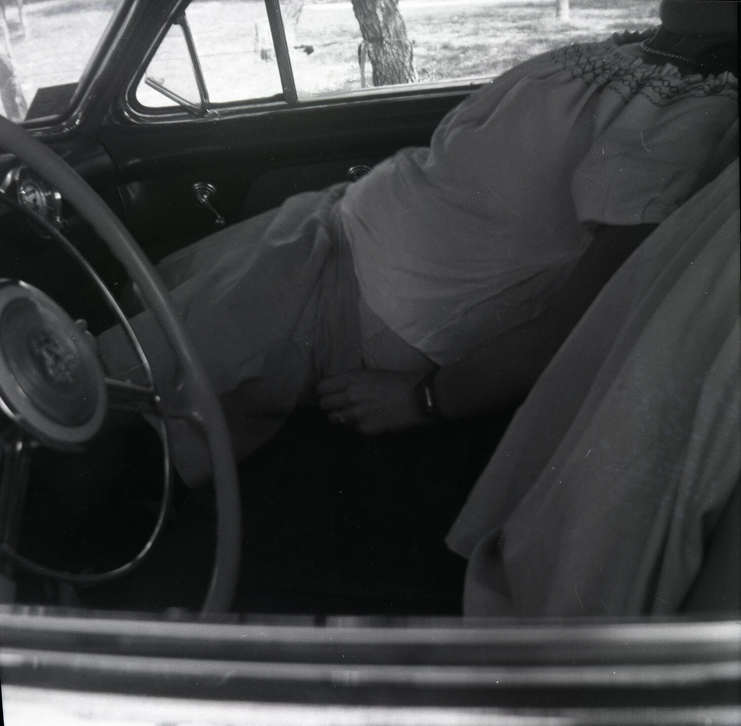 Interior View of a Vintage Sedan with a Woman Reclining on the Back Seat