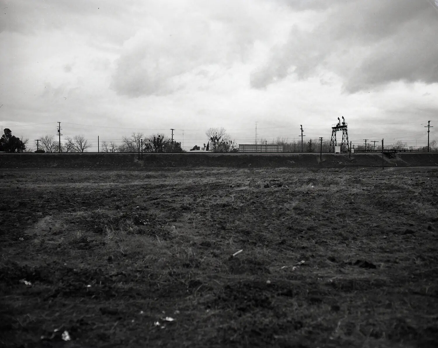 Vacant Field and Railway Embankment with Signal Gantry — Site Documentation Photograph