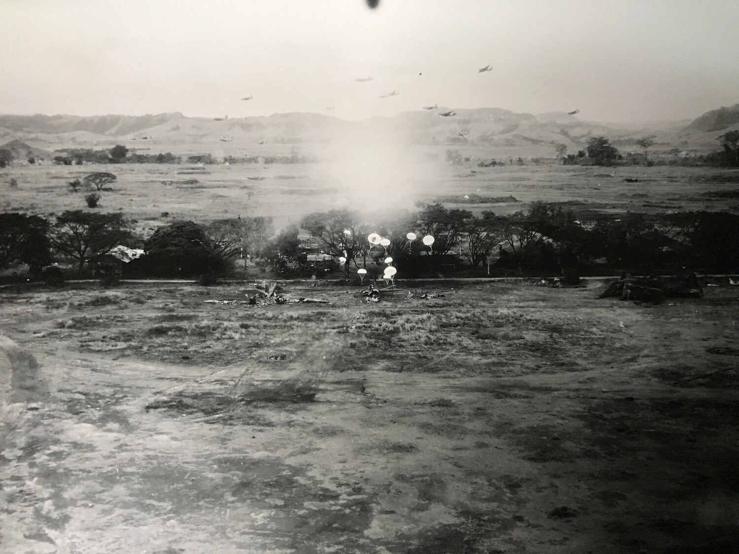 Aerial Photograph: Parafrag Bomb Attack on Airfield with B-25 Formation Overhead, Pacific Theater, WWII