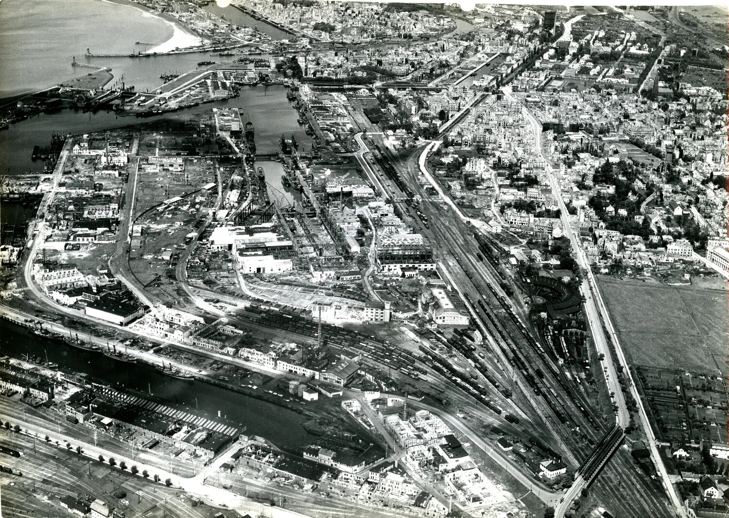 Aerial Reconnaissance Photograph of a Bomb-Damaged European Port City and Rail Yard, WWII European Theater