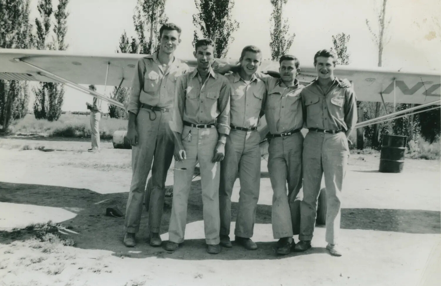 Group Portrait of Five Aviation Trainees Beside a Light Training Aircraft