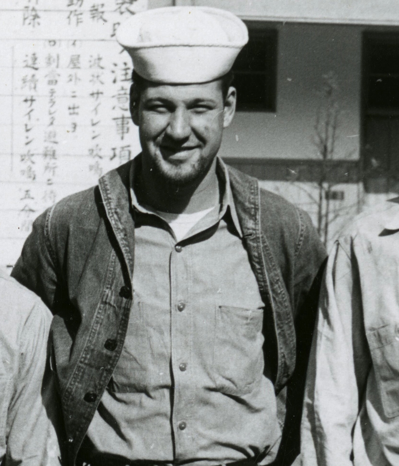 U.S. Navy Sailor Portrait Before Japanese-Language Signage, Korean War Era