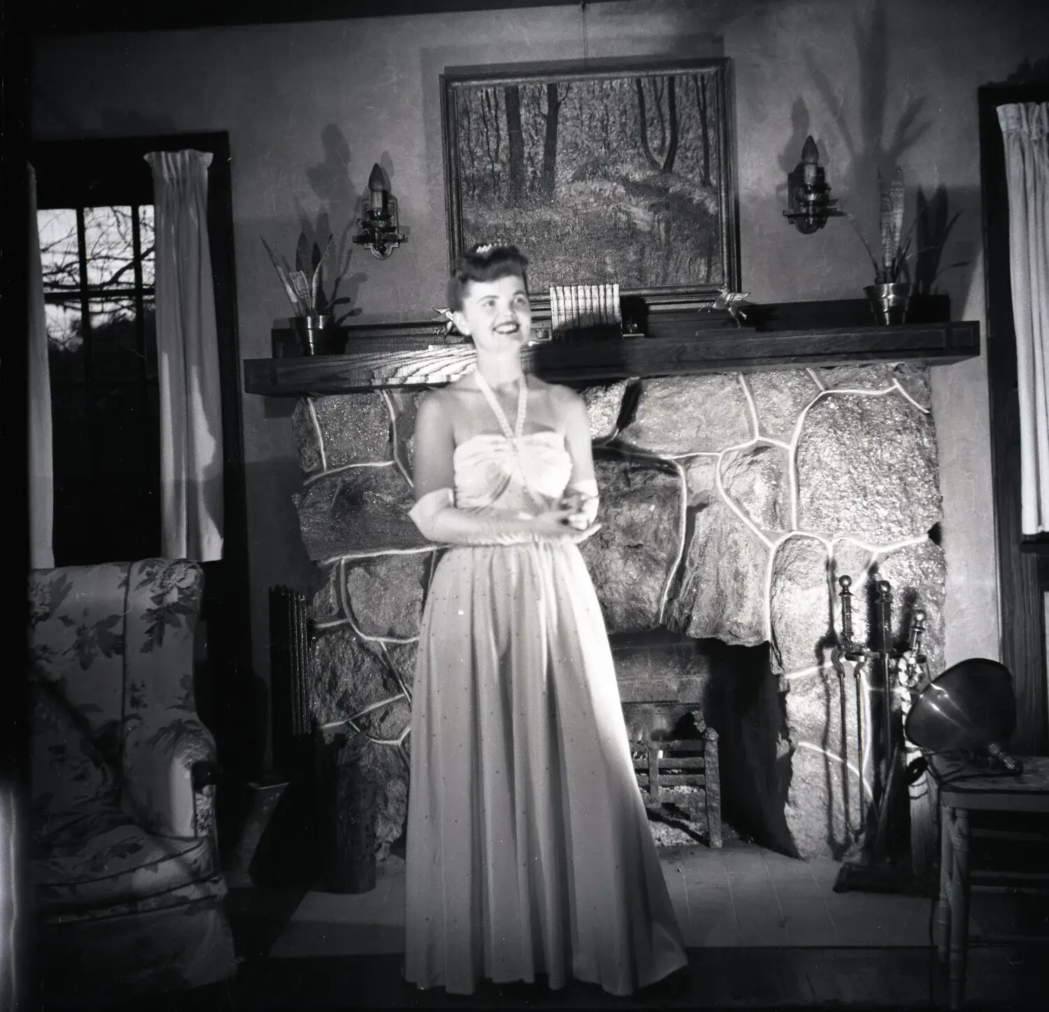 Young Woman in Evening Gown Before a Stone Fireplace, Domestic Interior