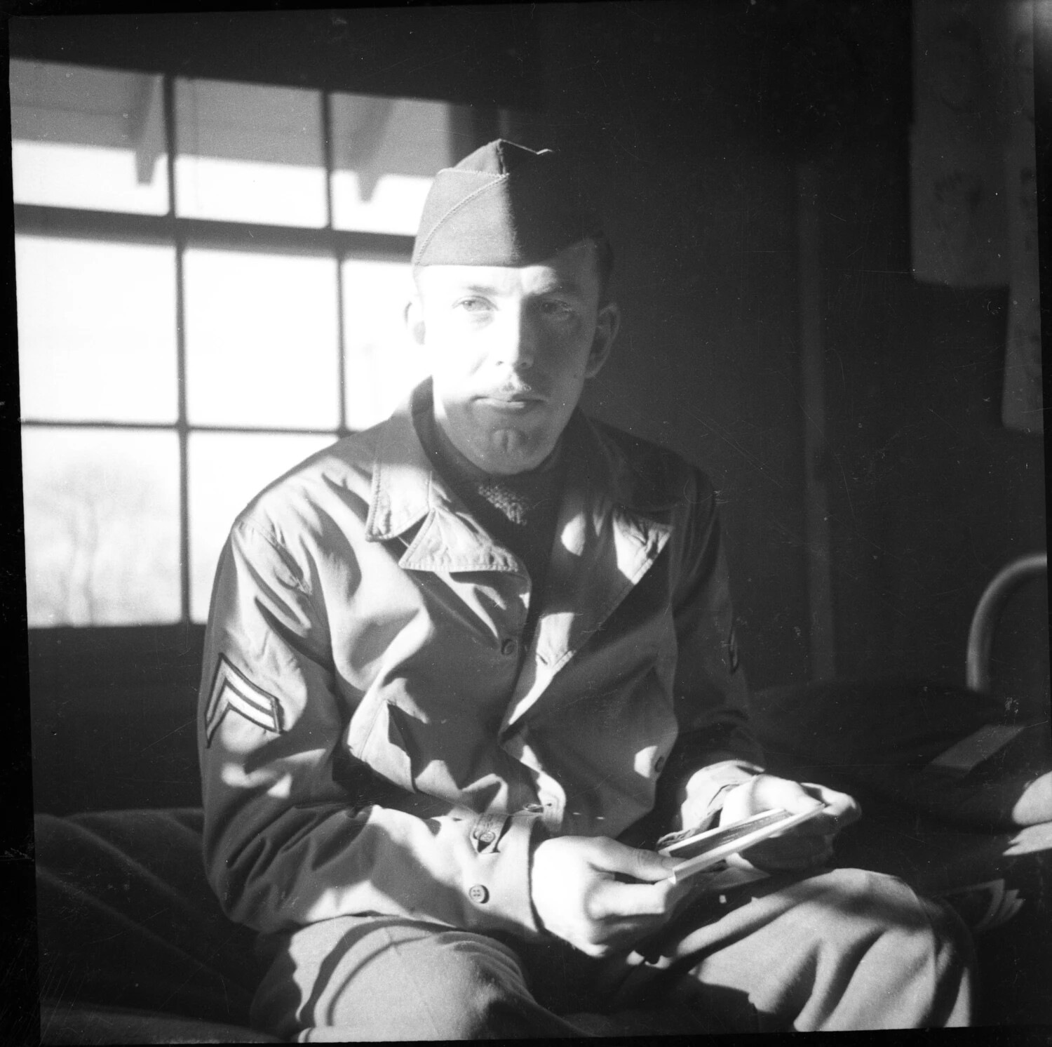 Portrait of U.S. Army Corporal Seated in Barracks, World War II Era