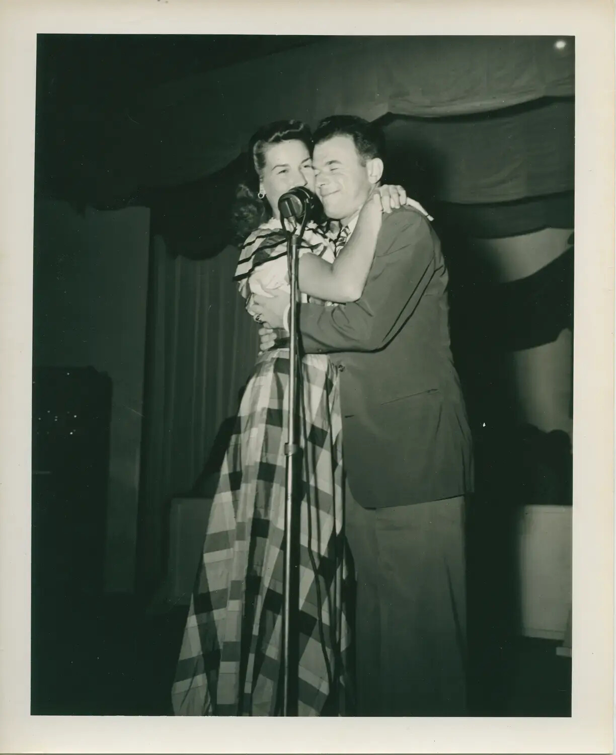 Couple Embracing on Stage at Microphone, USS Petrof Bay (CVE-80) Collection, WWII Era
