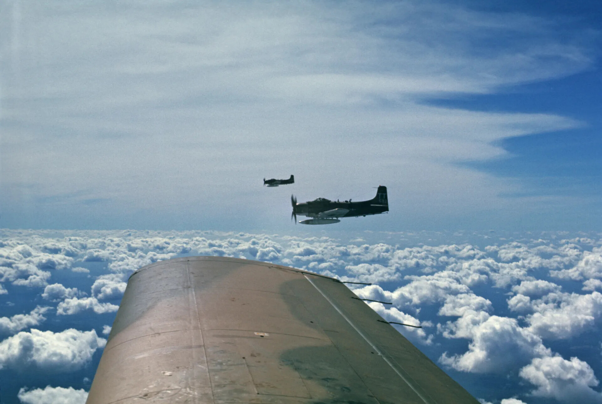 Two A-1 Skyraiders in Formation Above the Clouds, Photographed from a Third Aircraft