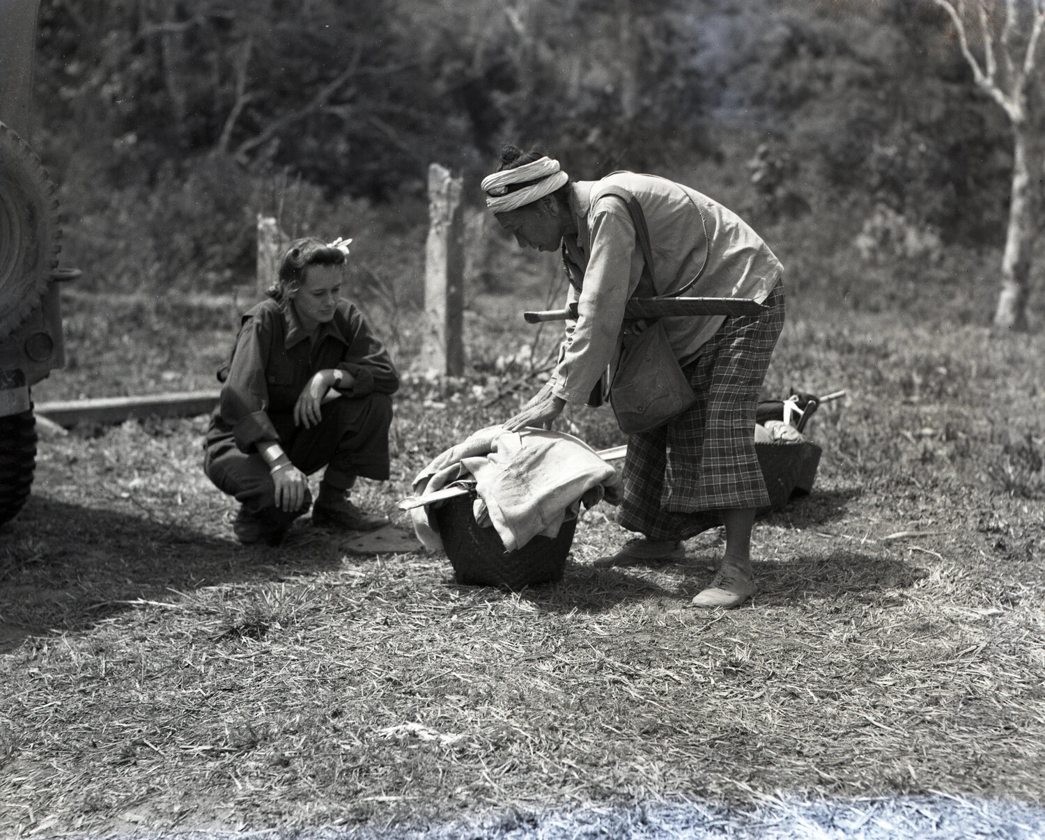 American Servicewoman Observing Local Burmese Man Packing Baskets, CBI Theater, WWII