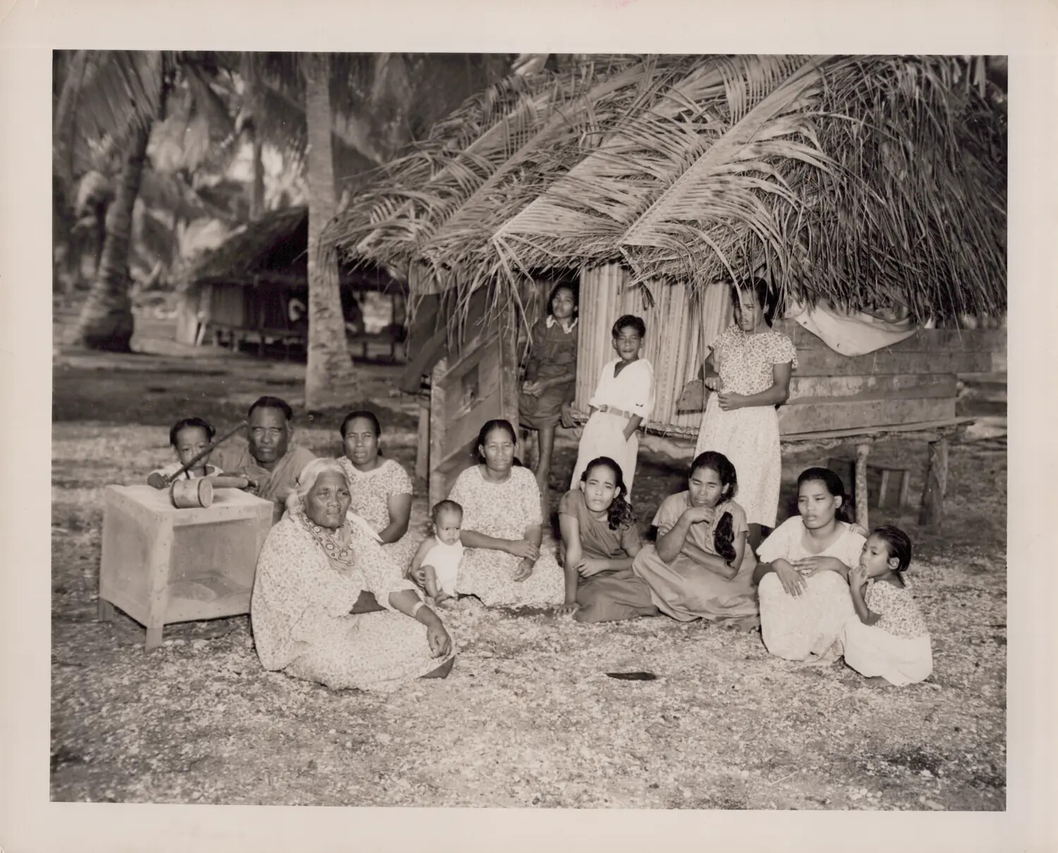 Pacific Islander Family Group Outside Thatched Dwelling, World War II-Era Photograph