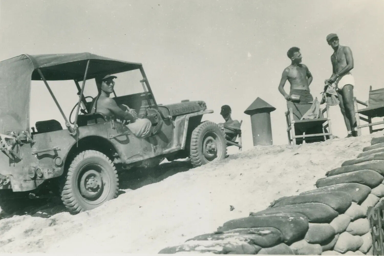 Servicemen Relaxing by a Jeep Near Sandbagged Position, WWII Coastal Base