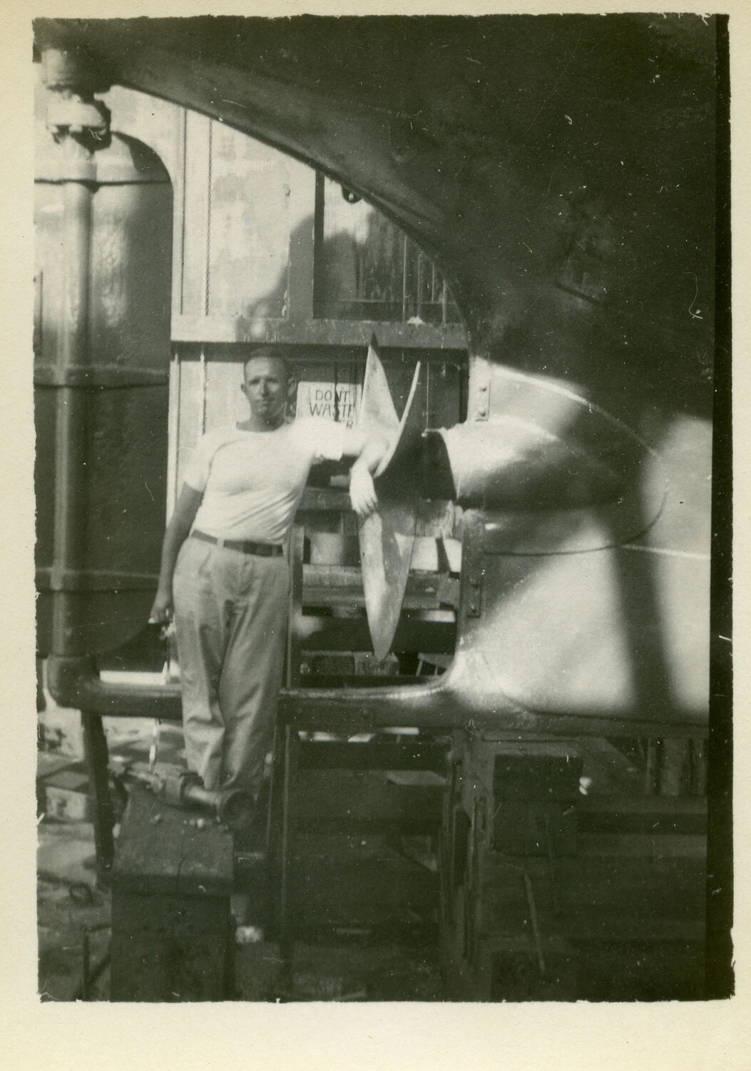 Sailor Posing Beside Ship's Propeller During Dry Dock Repairs, Pacific Theater, WWII