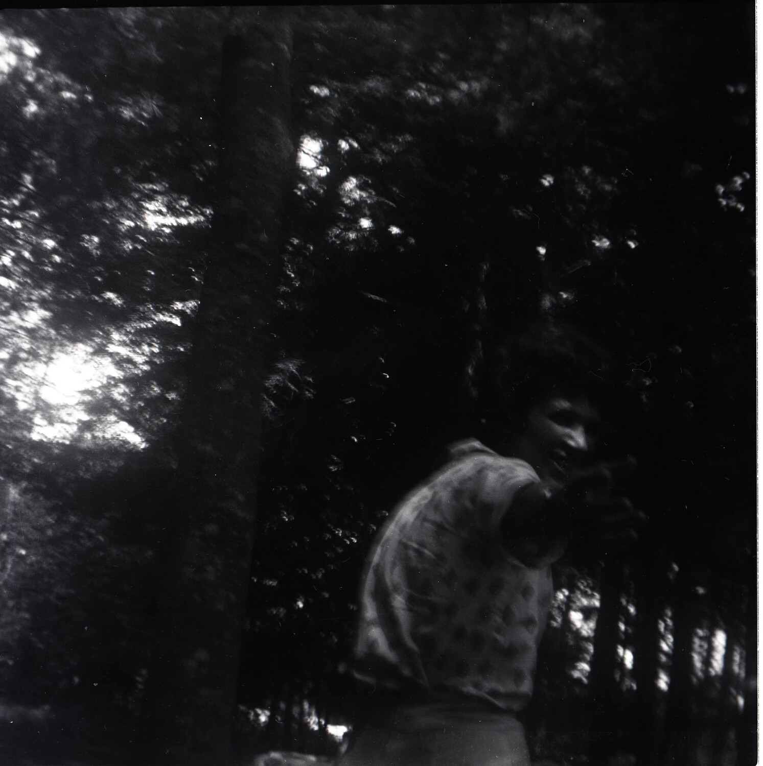 Man Turning Toward Camera in Forest Picnic Area, Blurred Snapshot, Mid-20th Century