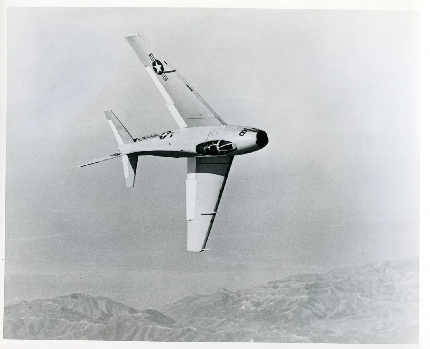 North American FJ-4 Fury Jet Fighter in Steep Banking Turn Over Mountainous Terrain