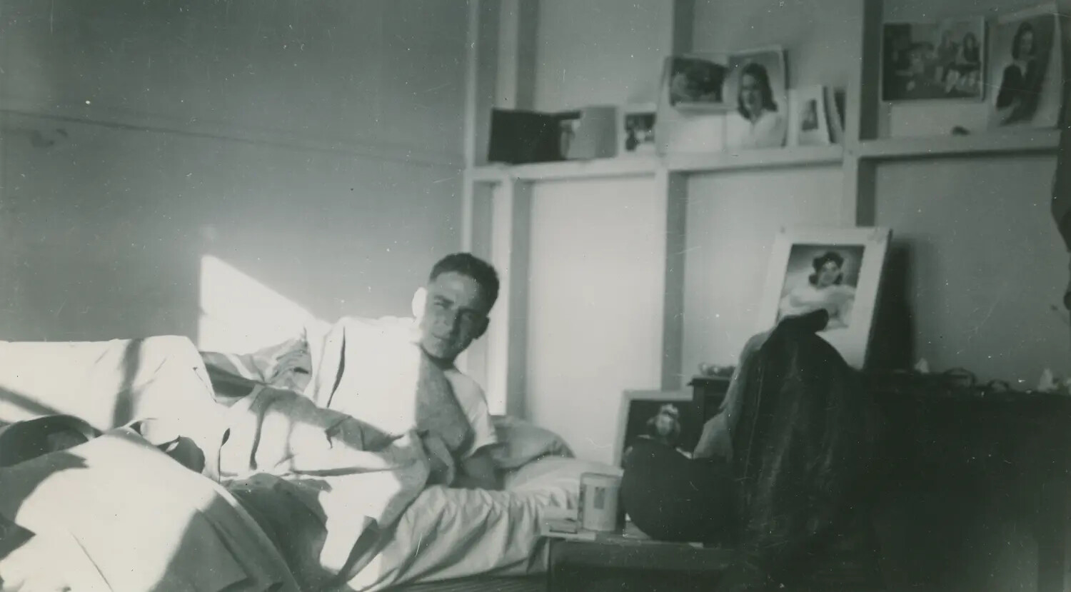 Serviceman Relaxing in Barracks Quarters with Photographs of Sweethearts on Shelf, WWII