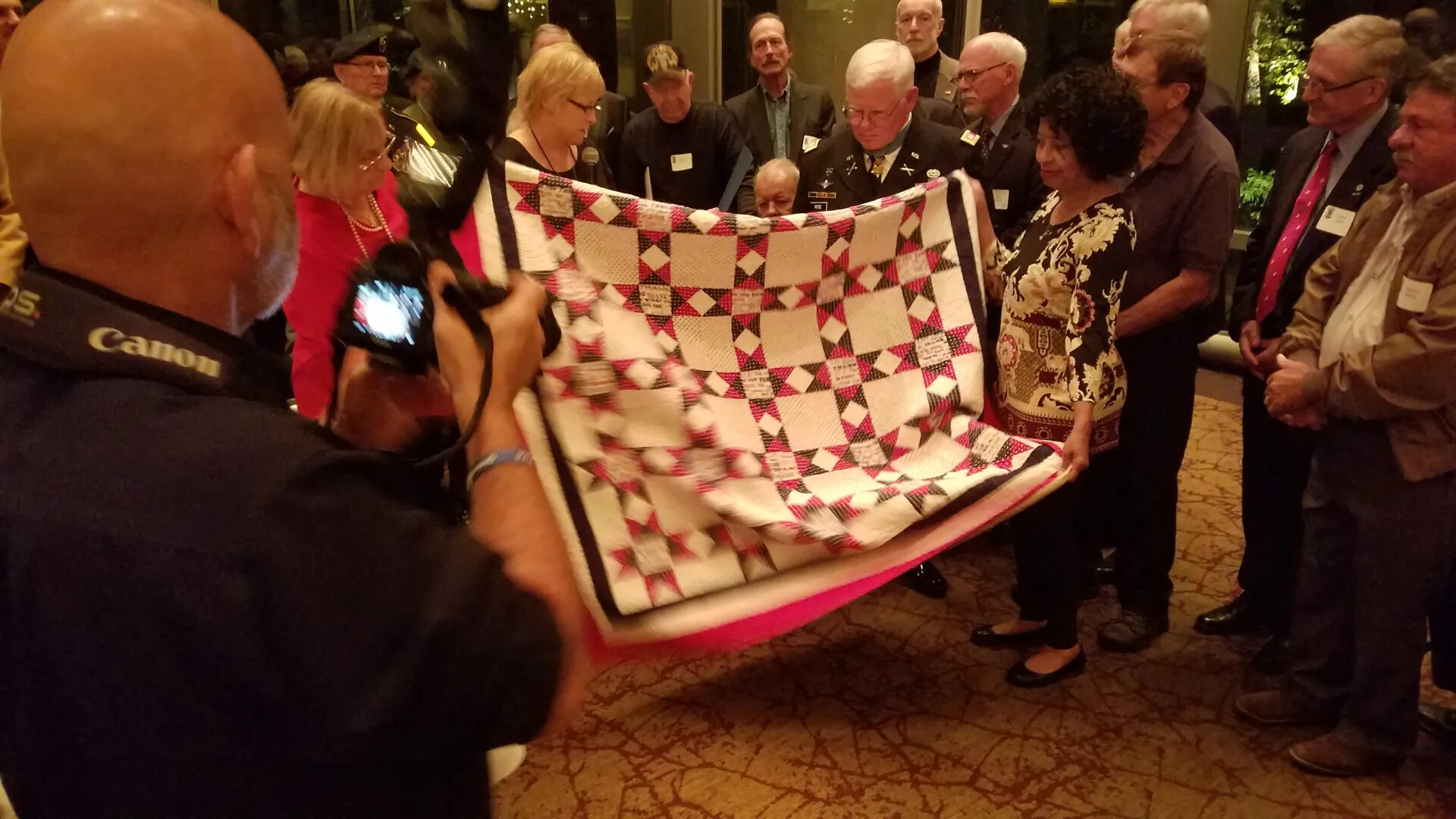 Veterans and Family Display Commemorative Tribute Quilt at Gary Michael Rose Medal of Honor Reception, October 23, 2017
