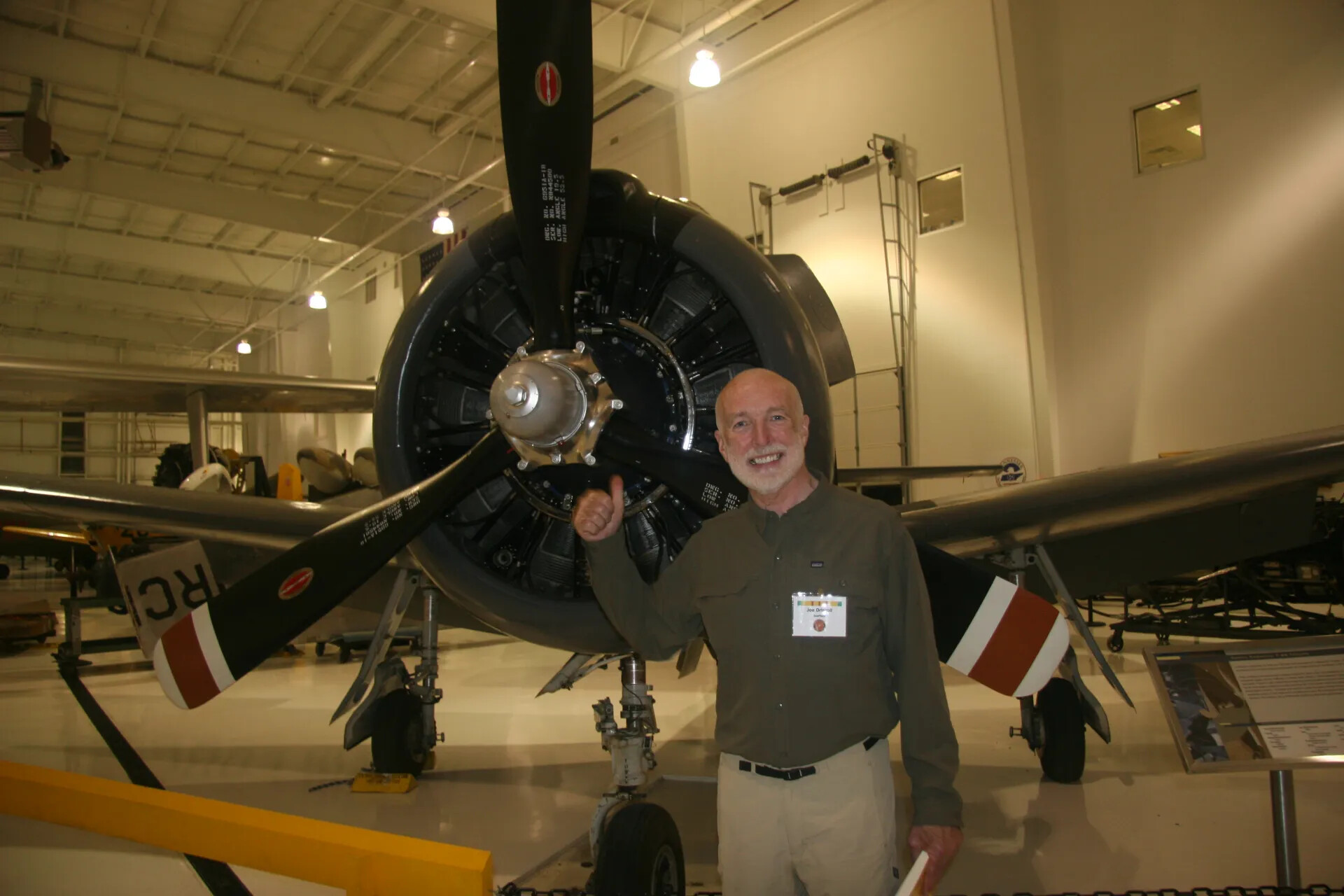 Reunion Attendee Posing with Radial Engine Aircraft, Aviation Museum Hangar