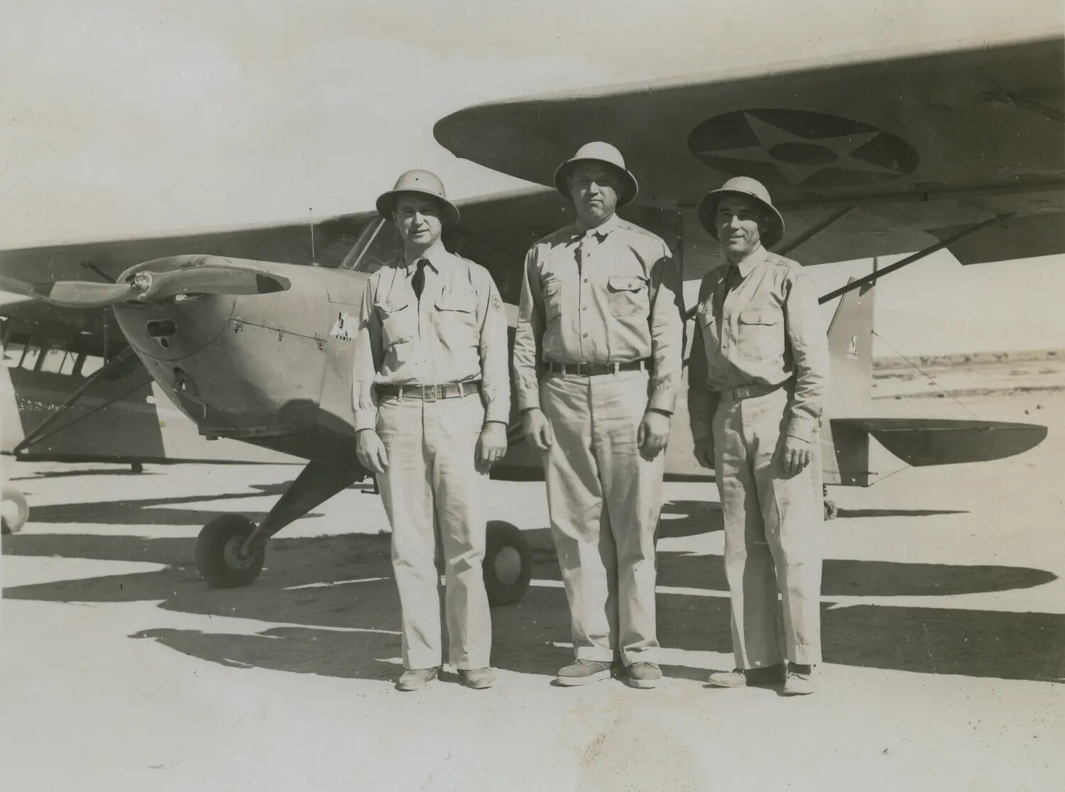 Three U.S. Army Air Corps Officers in Pith Helmets Beside Liaison Aircraft, Pre-1942 Insignia