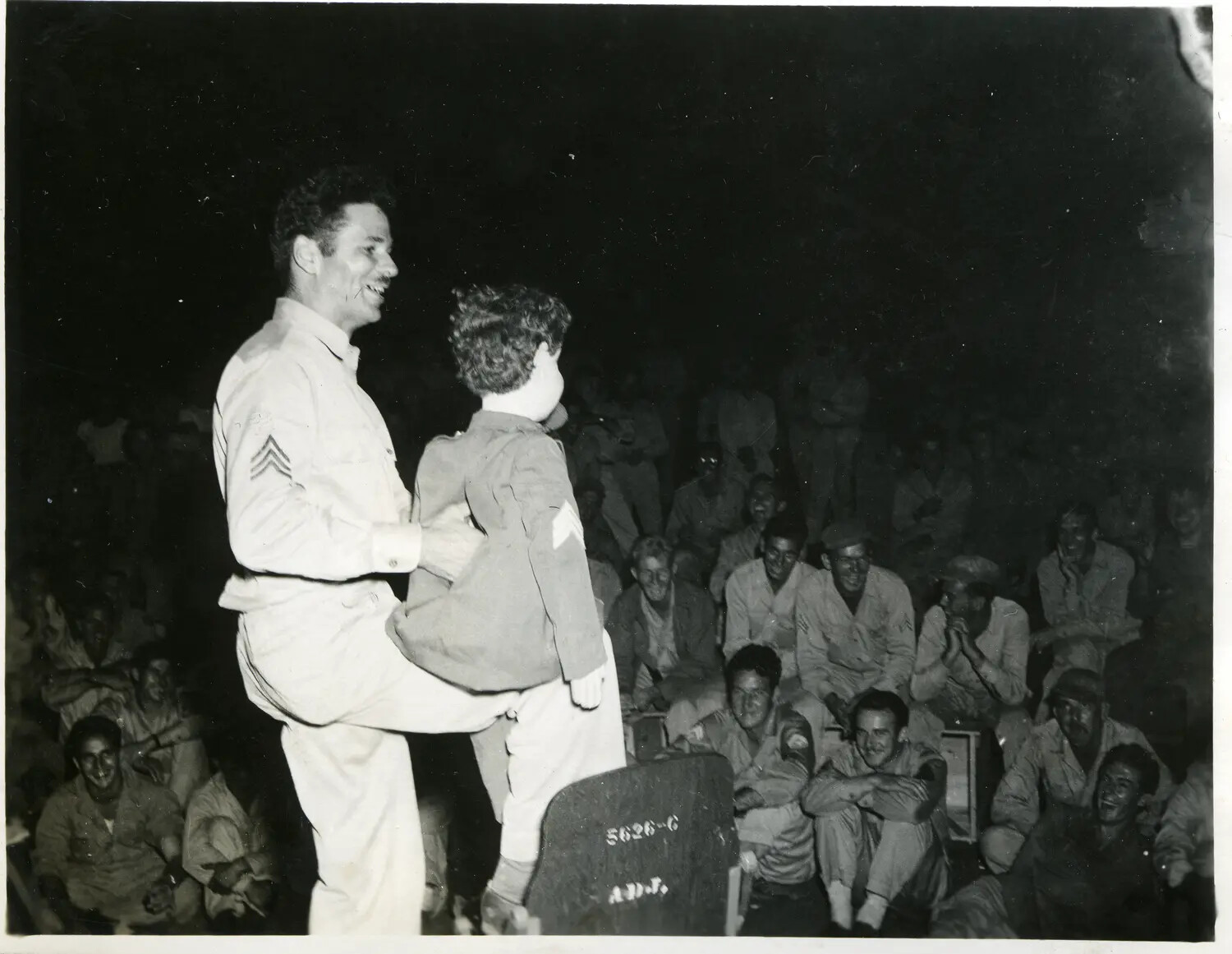 Sergeant Performing Comedy/Ventriloquist Act for Troops, 312th Bomb Group Area — Nighttime Entertainment