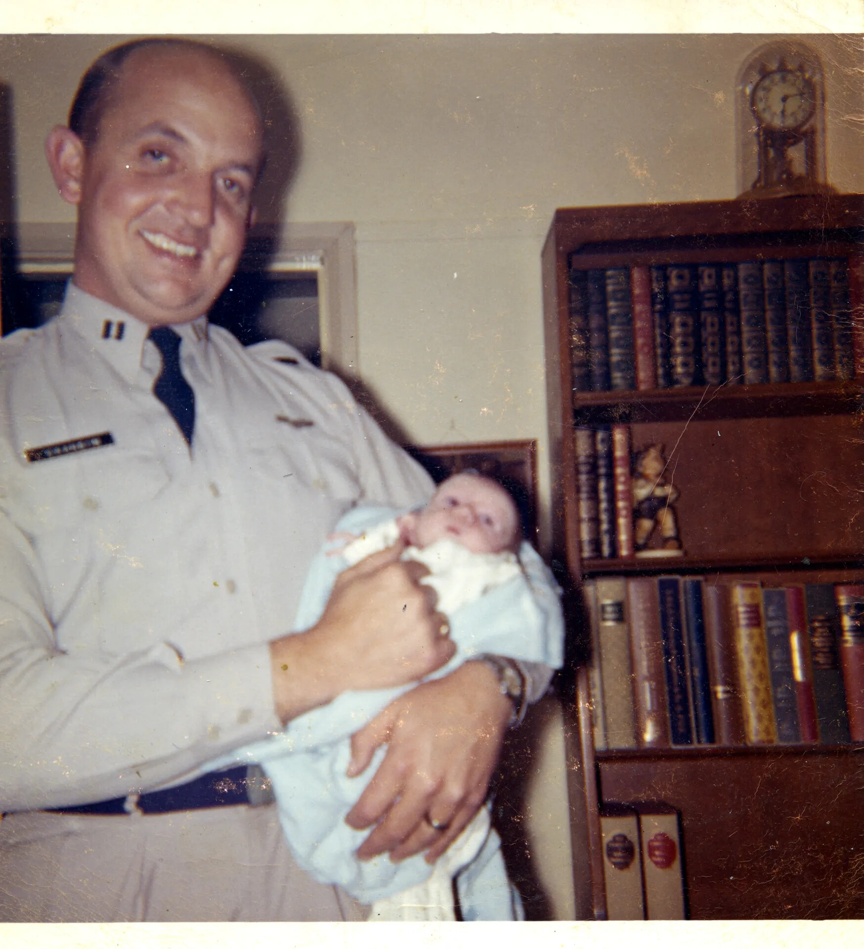 Uniformed Officer Holding Newborn Infant, September 10, 1963