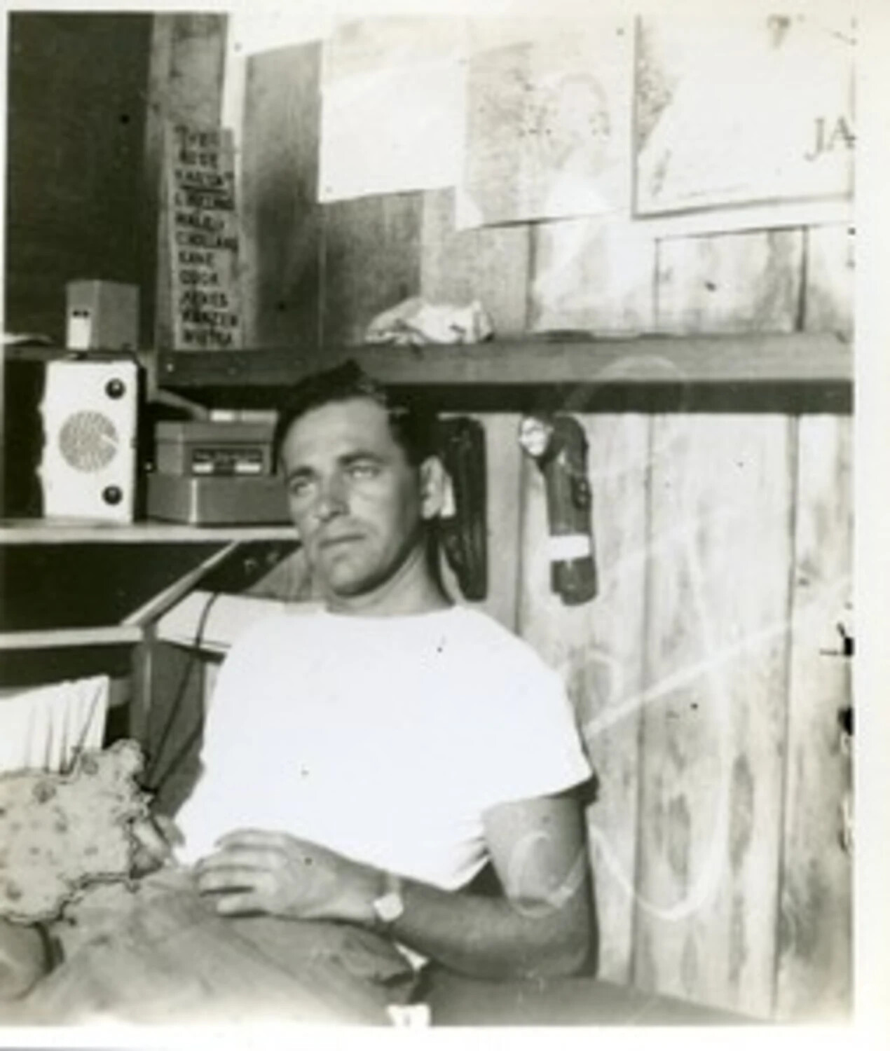 Serviceman Seated in Barracks Quarters with Roster List and Radio Equipment, WWII Pacific Theater (Joe Vieira Collection)