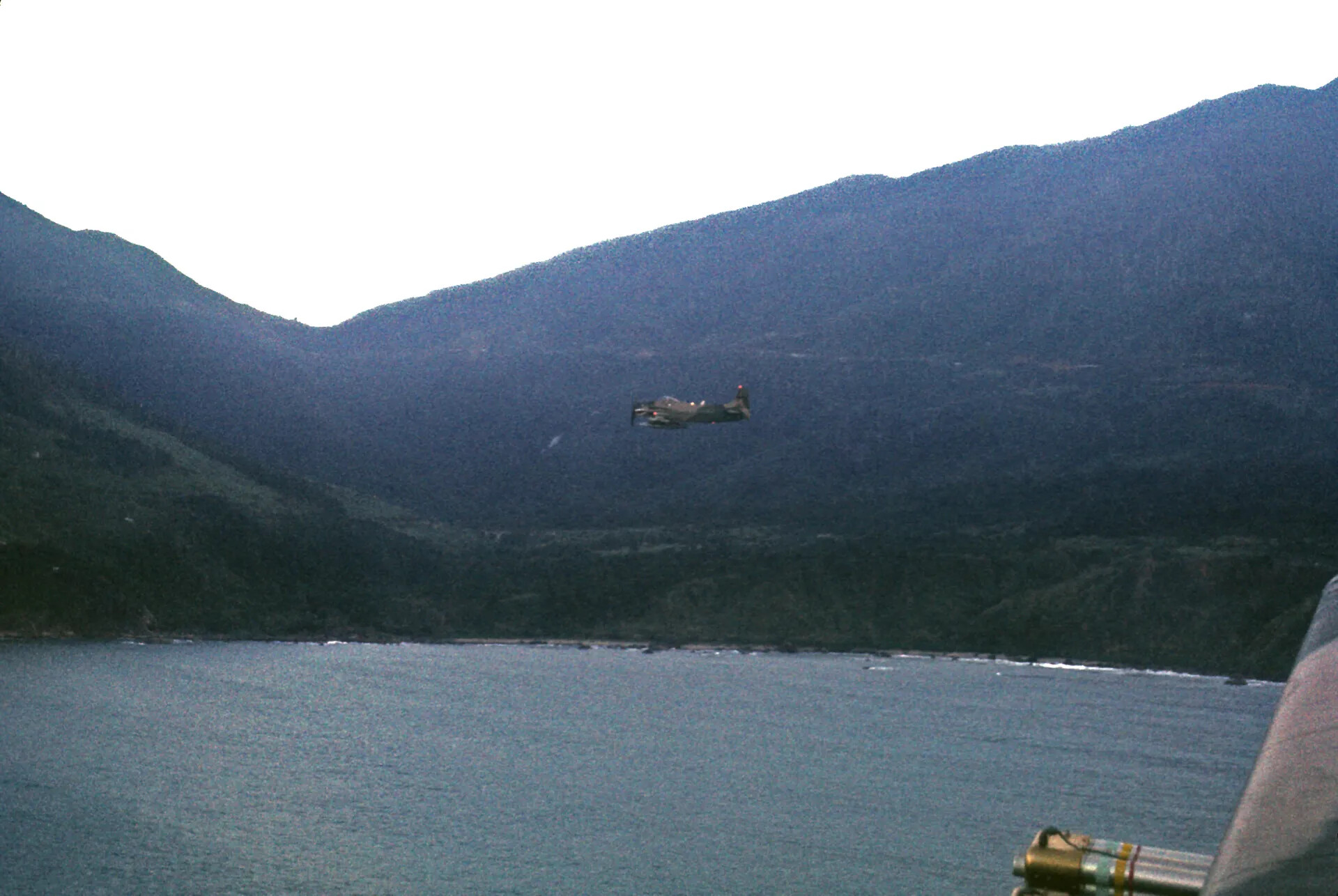 Air-to-Air View of Single-Engine Aircraft Over Coastal Bay