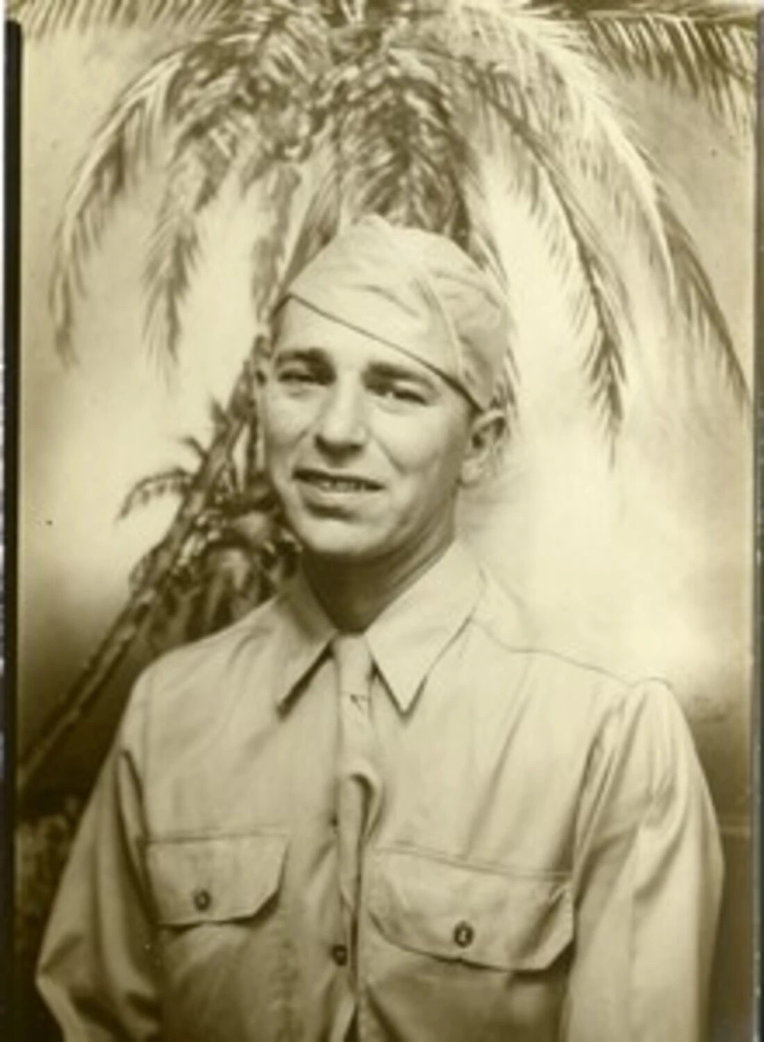 Studio Portrait of a Serviceman in Front of Painted Palm Tree Backdrop, WWII