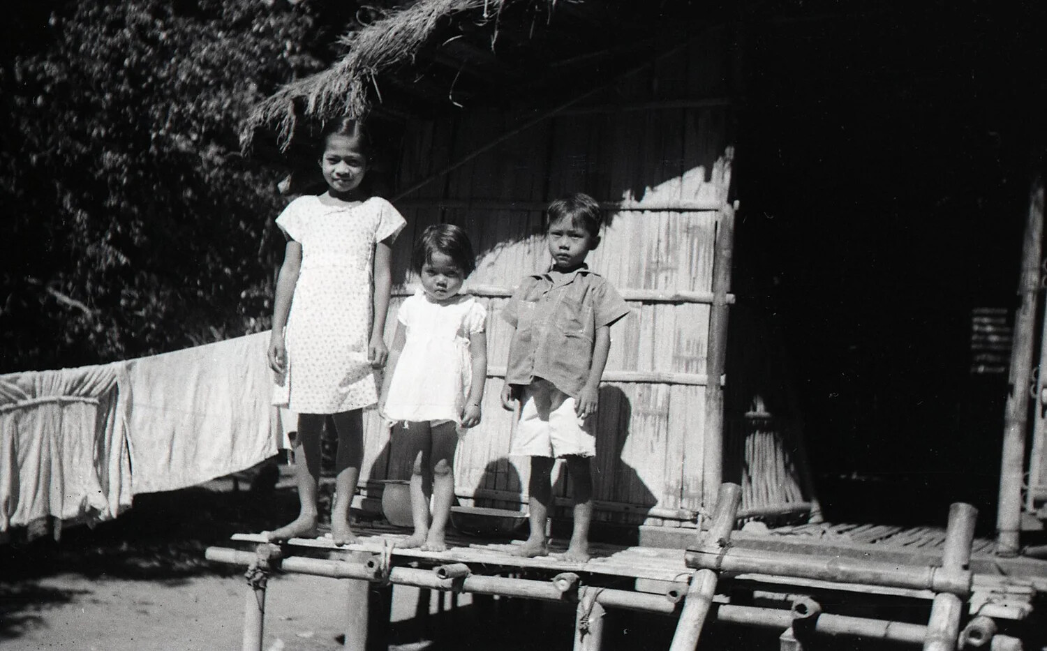 Three Filipino Children on Bamboo Porch, Luzon, Philippines, WWII Era