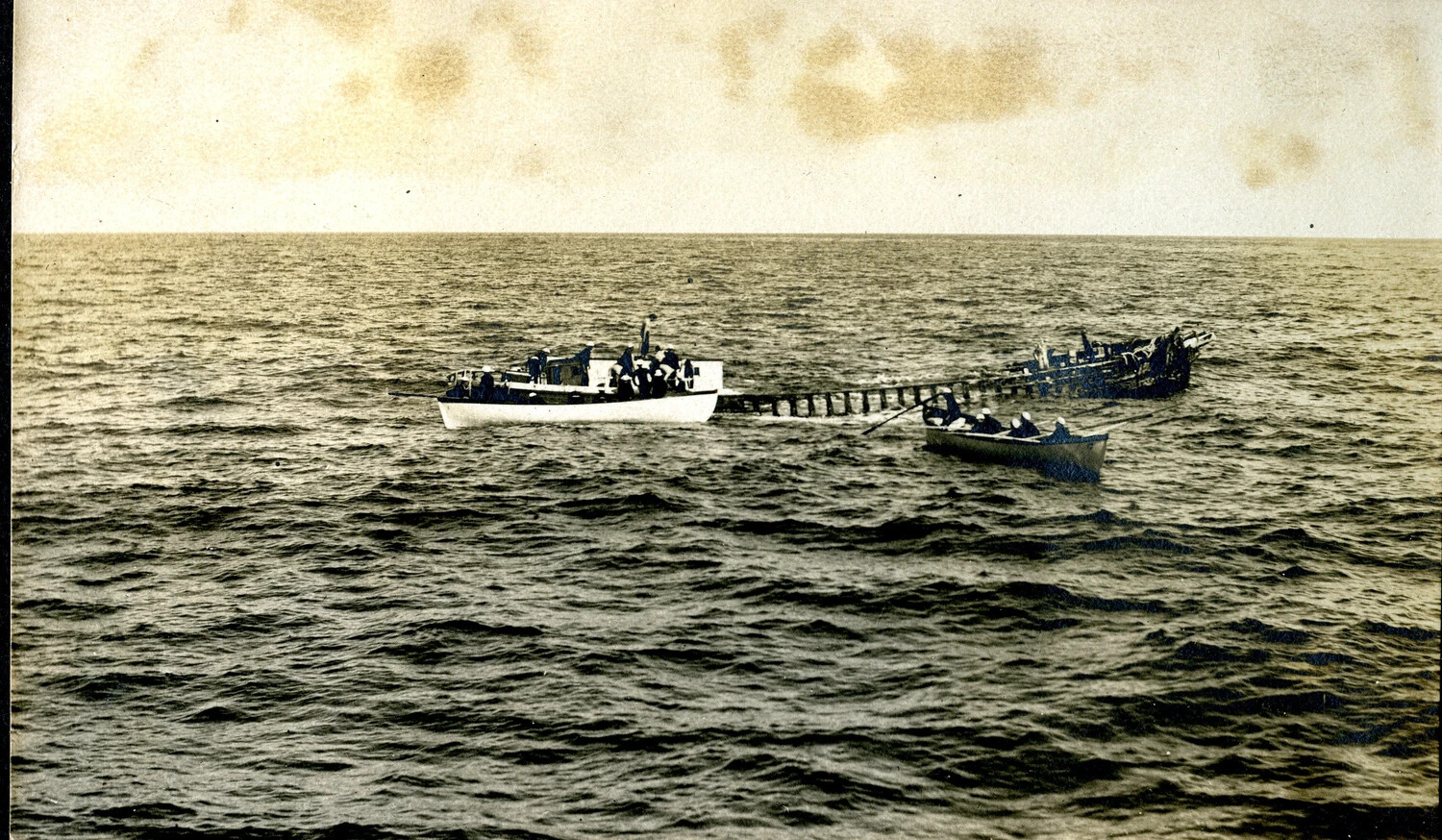 Ship's Boats Alongside a Capsized Derelict at Sea, USS Columbia Album, c. 1900-1910