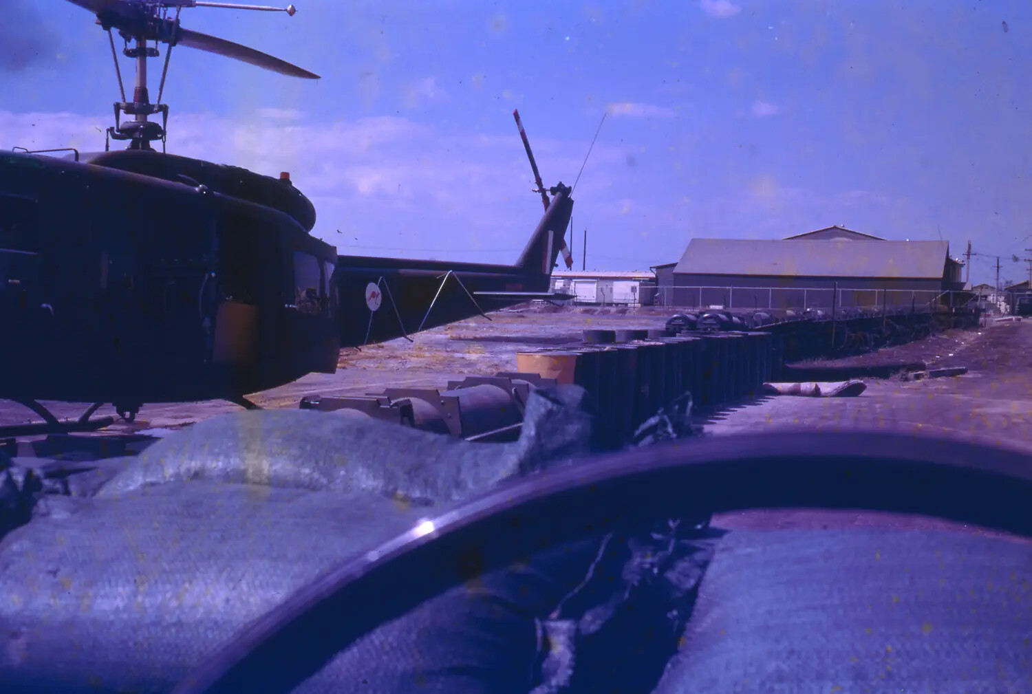 UH-1 Huey Helicopter on Flight Line Viewed Over Sandbagged Bunker, Vietnam, 1968 Tet Period