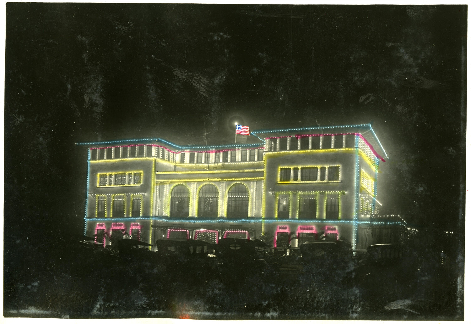 Building Illuminated with Festive Electric Lights and American Flag at Night, Philippines, Early 20th Century