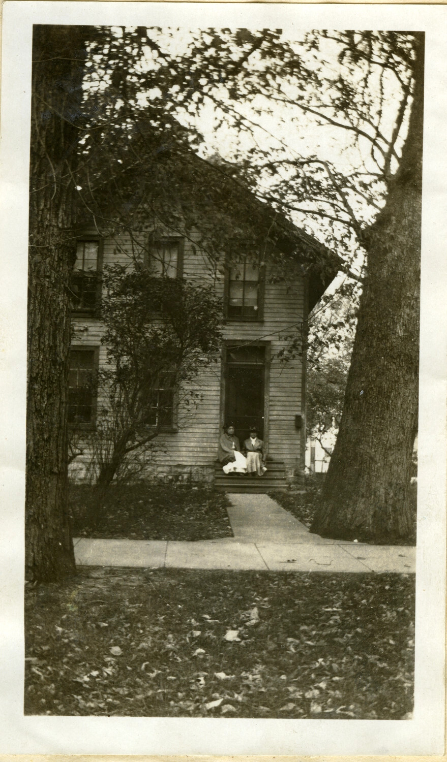 Stone Family Home, Minnesota — Two Women Seated on the Front Porch Steps