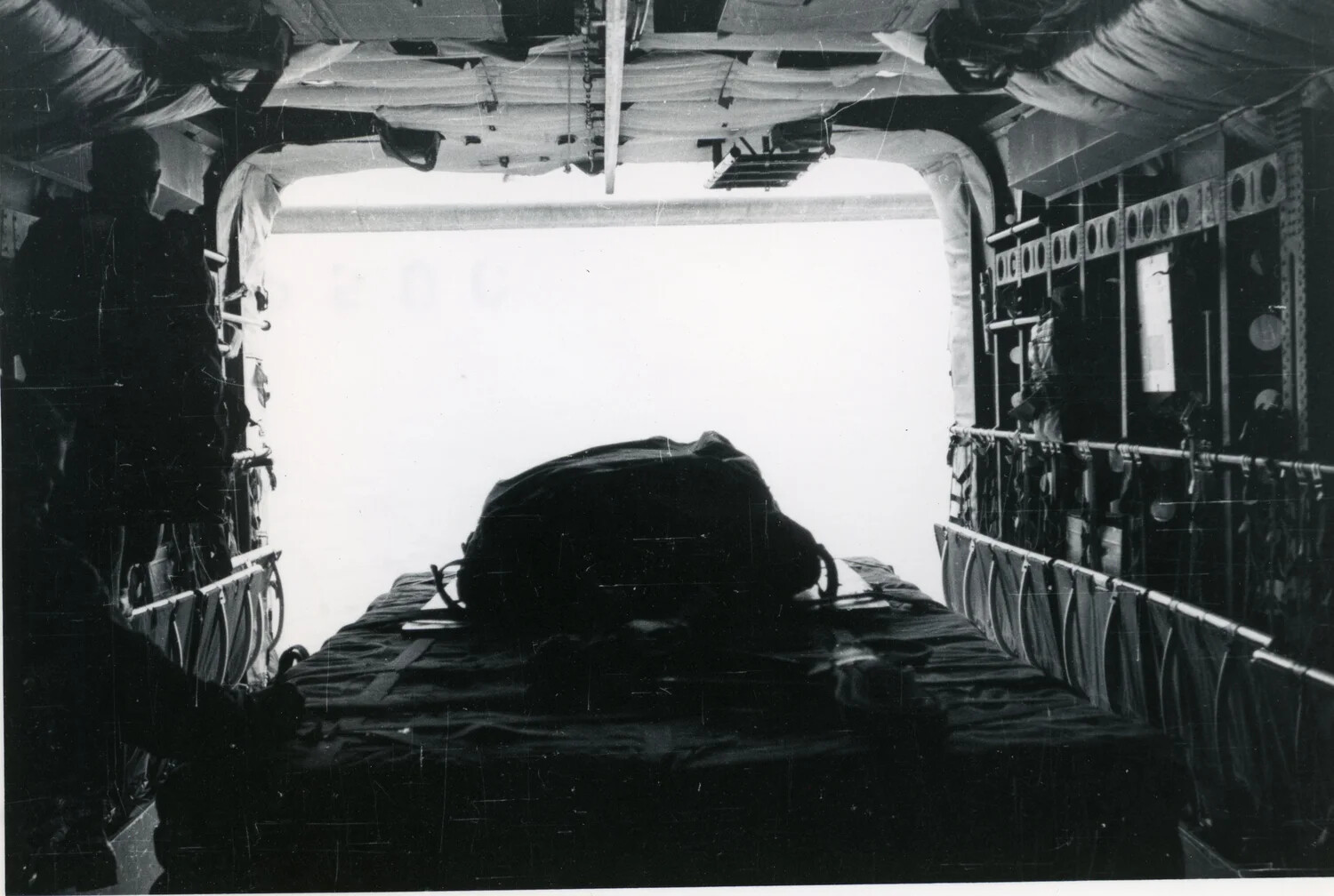 Cargo Bundle Positioned at Open Ramp of Military Transport Aircraft in Flight