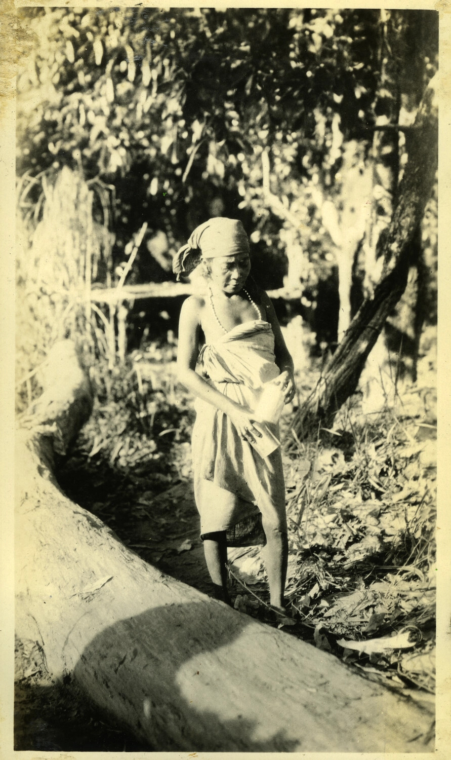 Elderly Woman in Traditional Dress Beside a Hollowed Log, Philippines, Early-Mid 20th Century