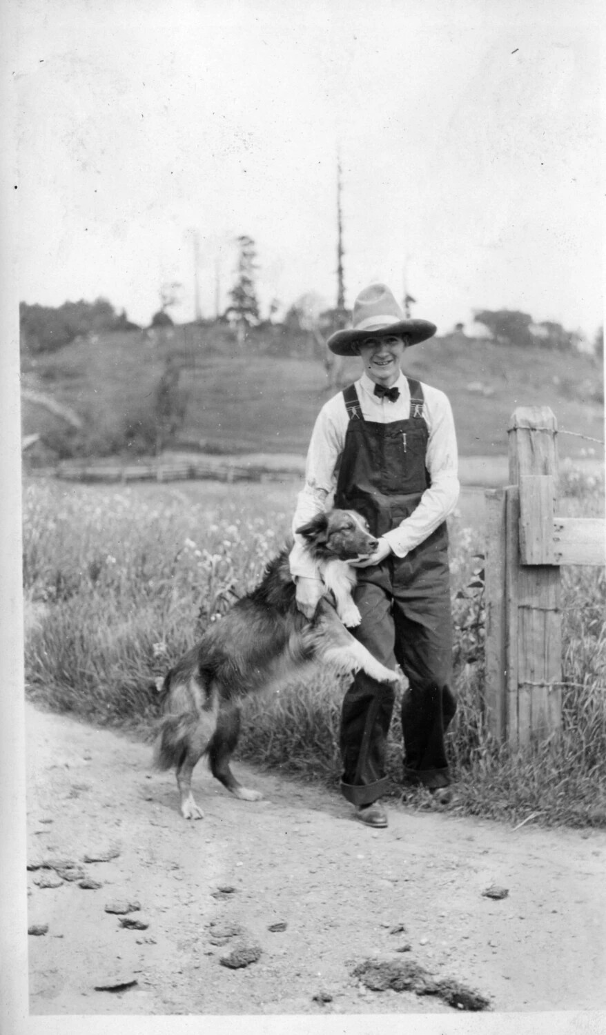 Young Man in Overalls with Collie Dog on Rural Road, Early 20th Century