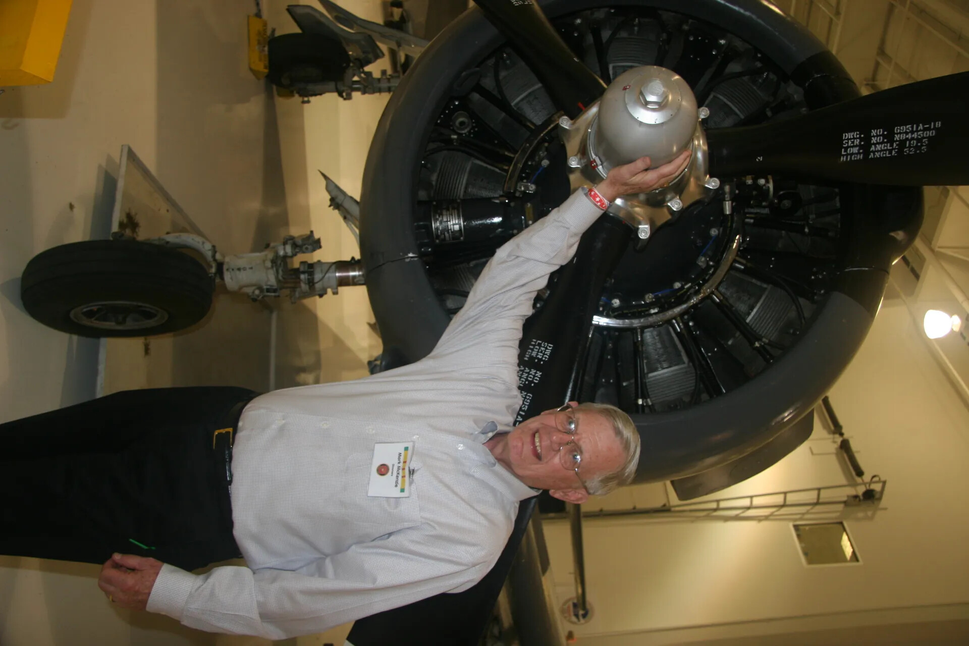 Museum Docent Mark McKenzie Examining Radial Engine and Propeller Hub of Vintage Aircraft