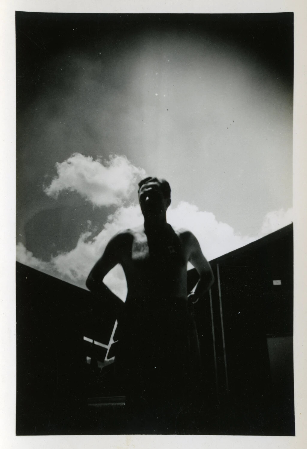 Silhouetted Serviceman with Hands on Hips Against Cloudy Sky, World War II Era